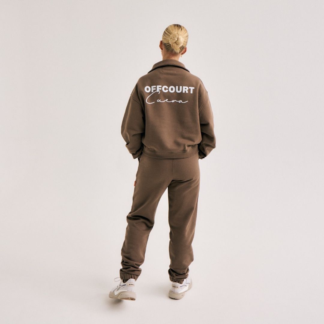 Model wearing Cuera Offcourt Cuera Sweat Pants in Walnut, back studio view