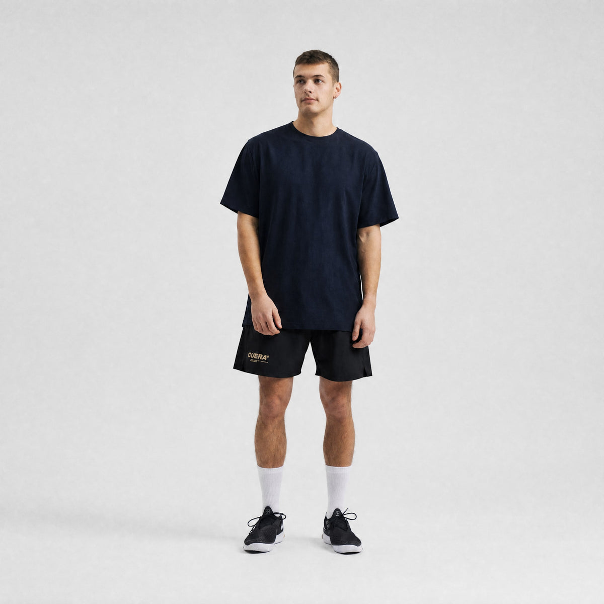 Model wearing Cuera Oncourt Breathe T-Shirt in Black, lifestyle action shot on the padel court