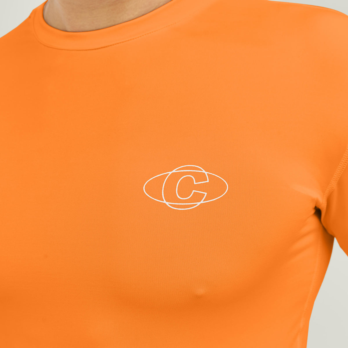 Model wearing Cuera Oncourt LS Layer T-Shirt in Orange, close-up detail on model